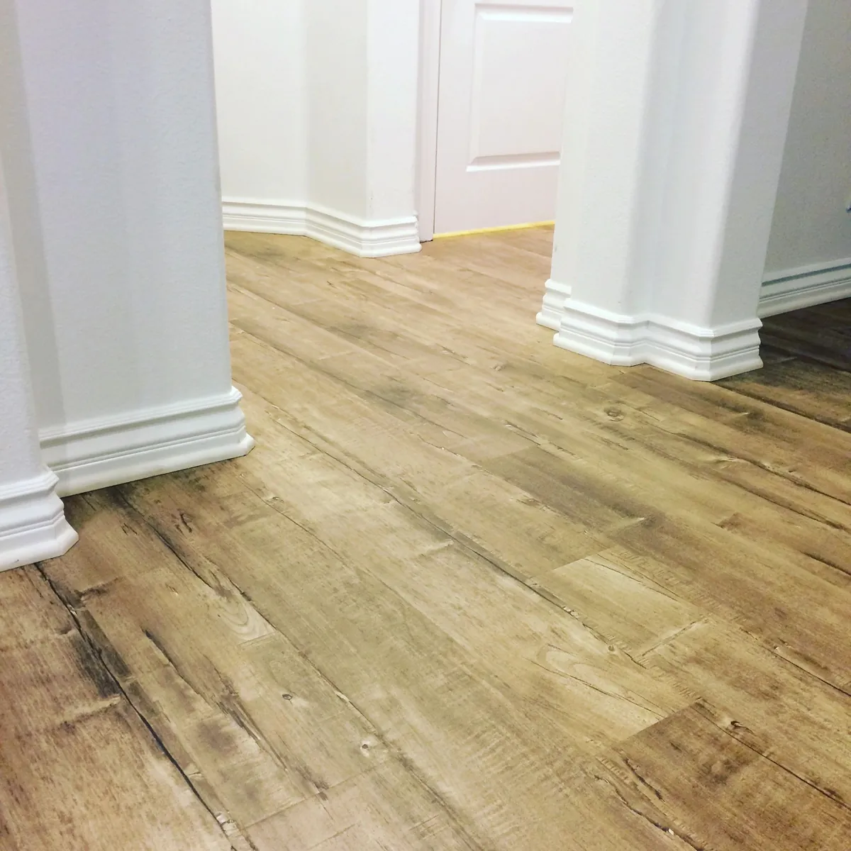 Laminate floor installed by Gagne Hardwood and Laminate, finished with baseboards in a Santa Ana home